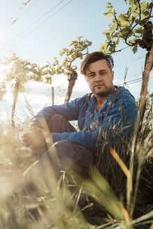 Winzer Christoph Hess sitzt im Weingarten in Neusiedl am See Burgenland