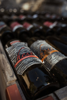 Weinflaschen mit verblichenem Etikett in einer Holzkiste
