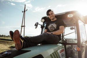 Christoph Hess sitzt auf der Motorhaube des Traktors
